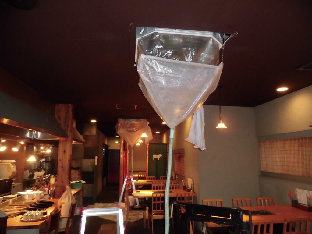 神戸市長田区の飲食店で業務用エアコン洗浄を行うため洗浄カバーで養生したクリーニング作業