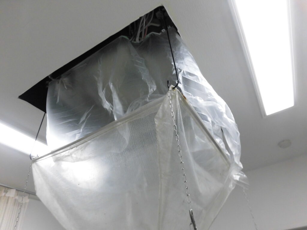 三宮の飲食店で業務用エアコン洗浄のため養生カバーを設置したクリーニング作業