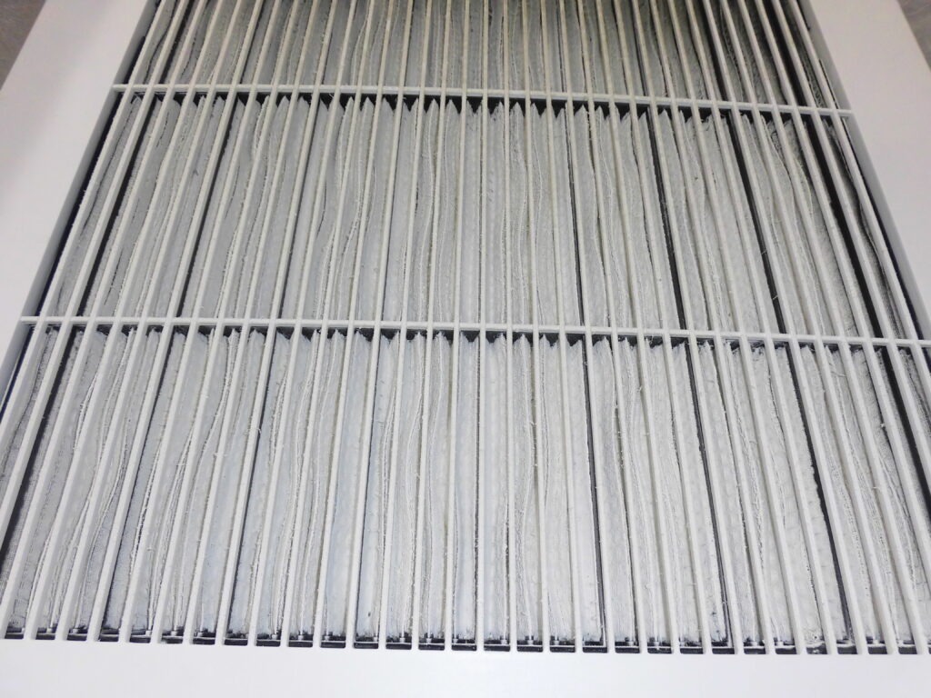 元町の美容室で業務用エアコンクリーニング前のフィルターに付着したホコリ汚れ